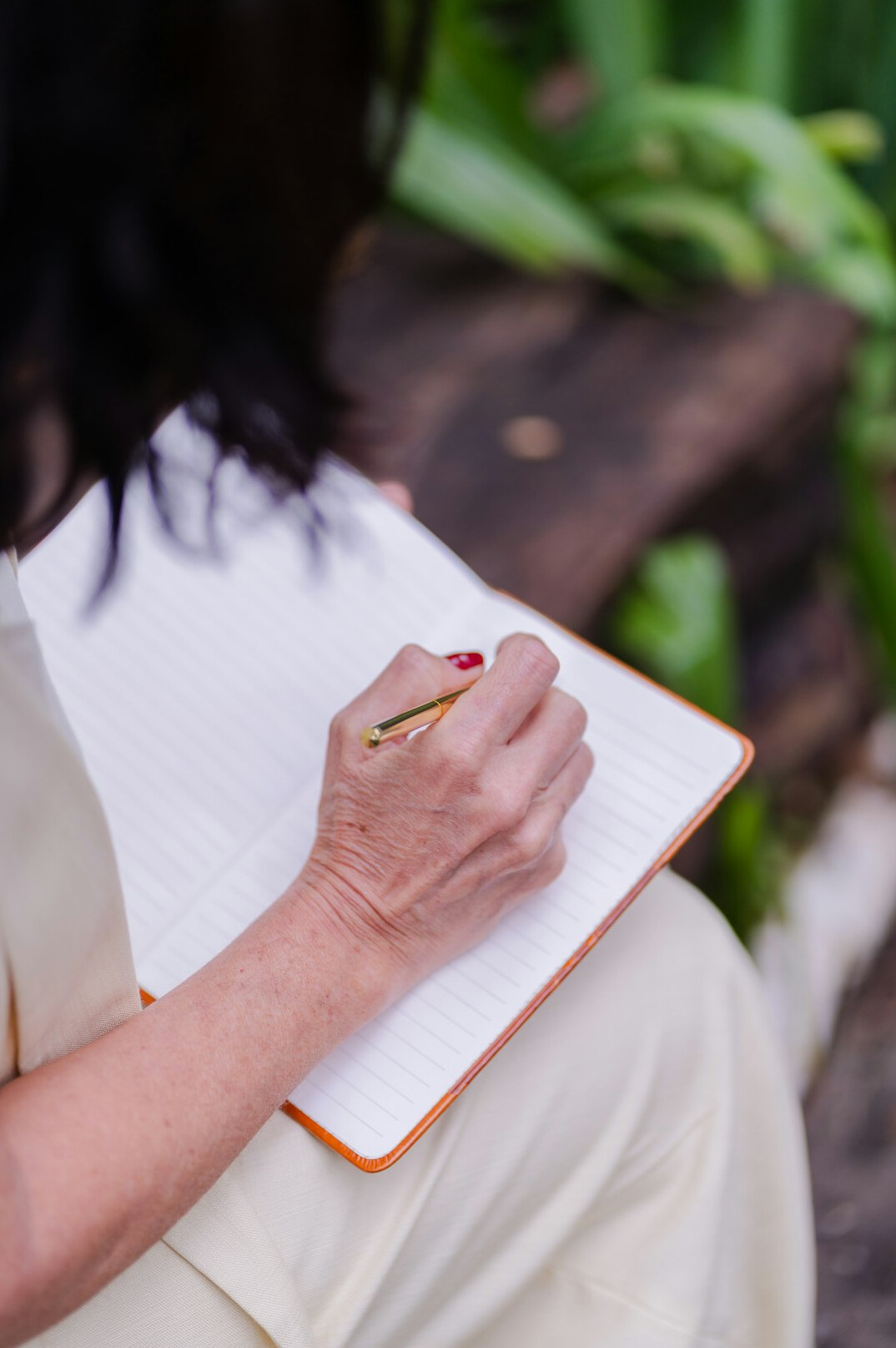 woman writing in journal outdoors