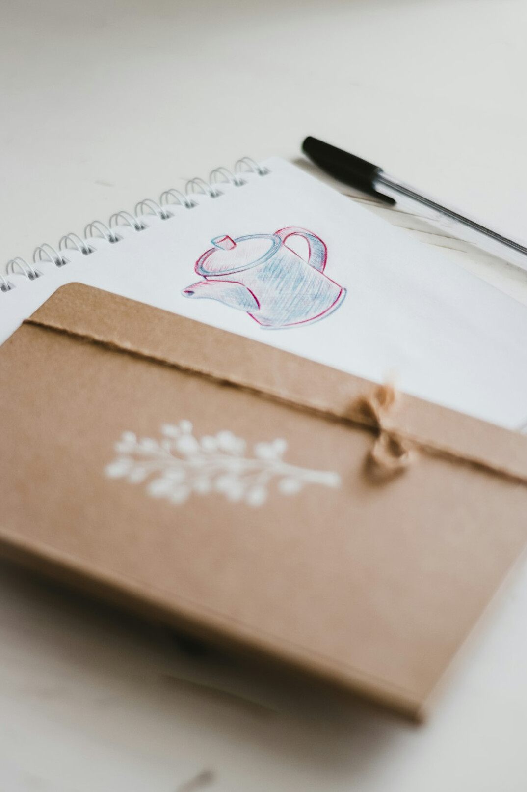 Open notebook with pen and a cup of coffee on a table